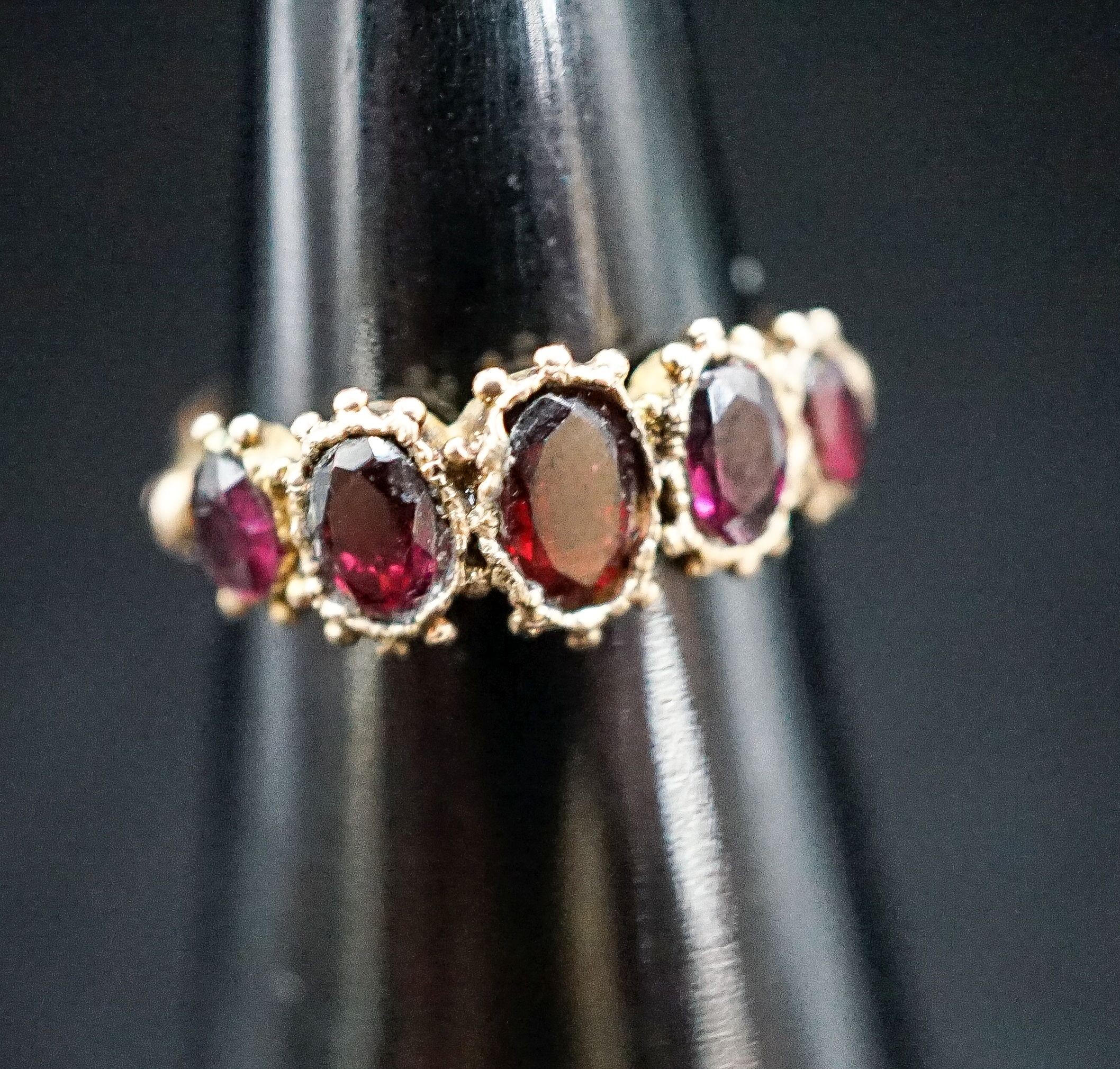 A 19th century yellow metal and graduated five stone garnet half hoop ring, size K, gross 2,.1 grams.
